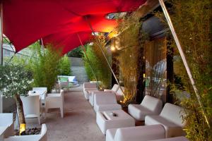 a row of white chairs and a red umbrella at Hotel Viura in Villabuena de Álava