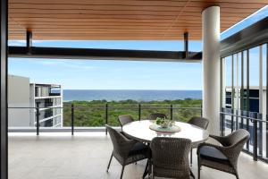 a dining room with a view of the ocean at Seanna Residences Bokarina Beach in Kawana Waters