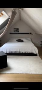 a white bed in a room with a ceiling at Lepadaloft in Villeneuve-Saint-Georges