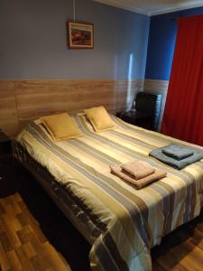 ein großes Bett mit zwei Handtüchern darüber in der Unterkunft Ananda in Ushuaia
