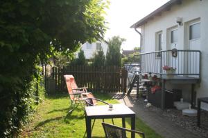 einen Garten mit Stühlen, einem Tisch und einem Haus in der Unterkunft Ferienwohnungen Haus Mecklenburg in Elmenhorst