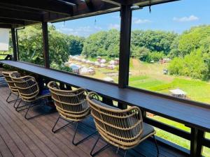 una terraza con sillas y un bar con vistas. en THE FARM Resort Japan en Katori