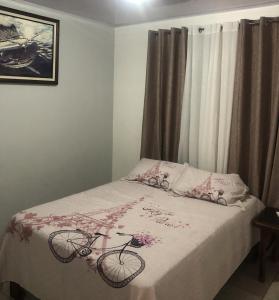 ein Schlafzimmer mit einem Bett mit rosa Blumen drauf in der Unterkunft Apartamento BYES in Quepos