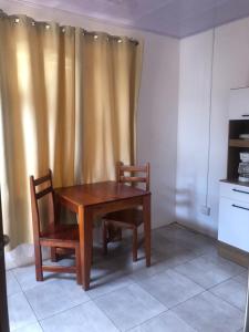 una mesa de madera y 2 sillas en la cocina en Apartamento BYES en Quepos