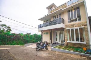 uma moto estacionada em frente a uma casa em Villa Zast Private Pool and Rooftop em Tlekung