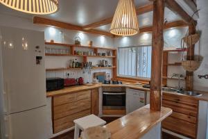 a kitchen with wooden cabinets and a white refrigerator at Bolonia Beach Campus in Tarifa