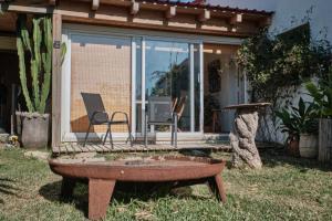 a house with a table and a chair in a yard at Bolonia Beach Campus in Tarifa