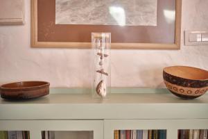 a glass vase on top of a shelf with two bowls at Bolonia Beach Campus in Tarifa
