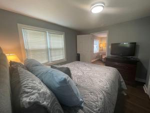 a bedroom with a bed and a flat screen tv at Cozy Home w/Deck & Fire Pit! in Greensboro