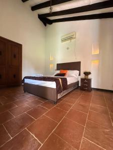 1 dormitorio con 1 cama y suelo de baldosa en Hacienda con Piscina Privada/Aire acondicionado/Jacuzzi en Santa Fe de Antioquia