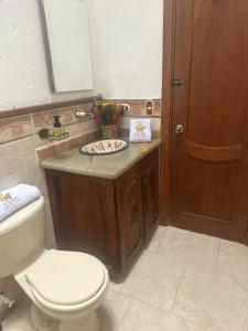 y baño con aseo y lavamanos. en Hacienda con Piscina Privada/Aire acondicionado/Jacuzzi en Santa Fe de Antioquia