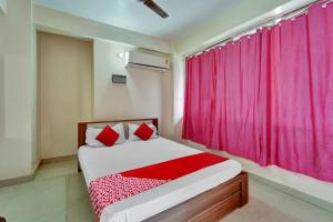 a bedroom with a bed with a red curtain at OYO Flagship Hotel CDS Regency in Patna