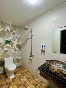 a bathroom with a shower and a toilet and a sink at Lapis Restaurant and Hostel in Vũ Lâm