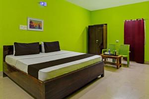a bedroom with a large bed with green walls at Khushi Guest House in Bhubaneshwar
