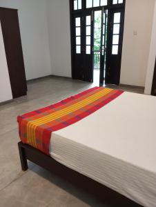 a bed with a colorful blanket on top of it at Nade Villas Ahungalla in Ahungalla