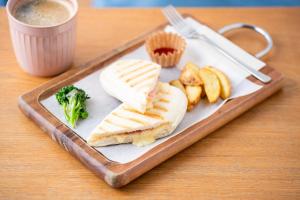 un piatto di cibo con un panino e broccoli su un tavolo di Imano Tokyo Hostel a Tokyo
