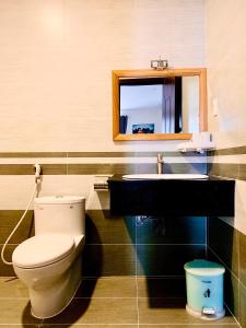 La salle de bains est pourvue de toilettes, d'un lavabo et d'un miroir. dans l'établissement SAO BĂNG HOTEL, à Thu Dau Mot