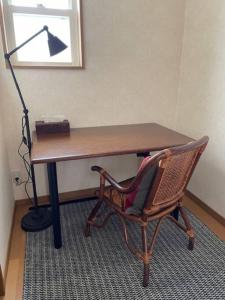 a desk with a chair and a lamp in a room at mimo’s cottage 斑尾山麓の庭付き貸切コテージ タングラムスキー場リフト乗場まで徒歩5分 in Madarao Kogen