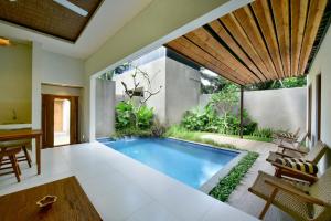 an indoor swimming pool in a house at Mahayoga Ubud Private Pool Villa And Spa in Ubud