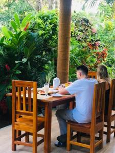 un homme et une femme assis à une table dans l'établissement Green Mountain Villa, à Ella