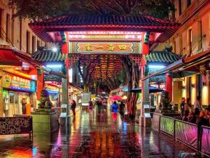 a city street at night with people walking in the rain at Cozy Lindfield Stayz in Sydney