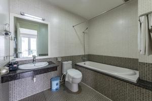 ein Badezimmer mit einer Badewanne, einem WC und einem Waschbecken in der Unterkunft Edoya Hotel Phu My Hung in Ho-Chi-Minh-Stadt