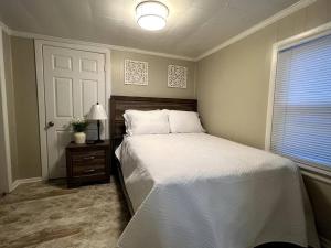 a bedroom with a large white bed and a window at Relax in Privacy in 2BR Beauty w/ Fire Pit & Grill in Greensboro