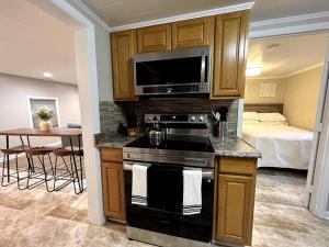 a kitchen with a stove and a bedroom with a bed at Relax in Privacy in 2BR Beauty w/ Fire Pit & Grill in Greensboro