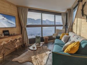 a living room with a blue couch and a large window at Appartement Val Thorens, 2 pièces, 5 personnes - FR-1-640-56 in Val Thorens