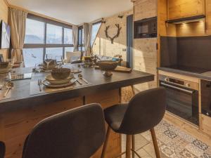 cocina con encimera y 2 sillas en una habitación en Appartement Val Thorens, 2 pièces, 5 personnes - FR-1-640-56 en Val Thorens