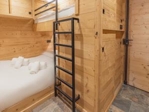 a bunk bed in a wooden room with a ladder at Appartement Val Thorens, 2 pièces, 5 personnes - FR-1-640-56 in Val Thorens