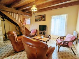 ein Wohnzimmer mit Ledermöbeln und einer Treppe in der Unterkunft Gîte Saint-Hilaire-sur-Benaize, 2 pièces, 3 personnes - FR-1-591-575 in Saint-Hilaire-sur-Bénaize