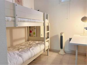 a bunk bed in a room with a desk at Appartement Le Lavandou, 2 pièces, 6 personnes - FR-1-251-546 in Le Lavandou
