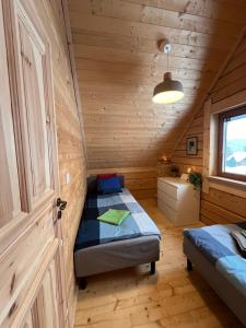 ein Schlafzimmer mit einem Bett in einer Holzhütte in der Unterkunft Chata na Łazach in Piwniczna-Zdrój