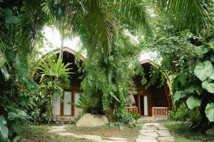 une maison avec un palmier en face dans l'établissement Uma Linggah Resort, à Tampaksiring
