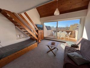 ein Wohnzimmer mit einem Sofa und einem großen Fenster in der Unterkunft Appartement Marseillan-Plage, 2 pièces, 6 personnes - FR-1-387-201 in Marseillan