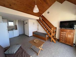 ein Wohnzimmer mit einer Treppe, einem Sofa und einem Tisch in der Unterkunft Appartement Marseillan-Plage, 2 pièces, 6 personnes - FR-1-387-201 in Marseillan