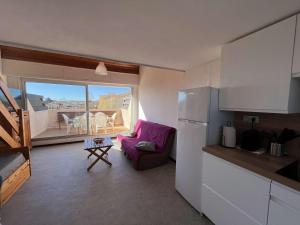 eine Küche mit einem lila Stuhl und einem Balkon in der Unterkunft Appartement Marseillan-Plage, 2 pièces, 6 personnes - FR-1-387-201 in Marseillan