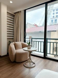- un salon avec une chaise et une table dans l'établissement TINH ANH HOME, à Hanoï