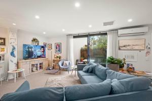 a living room with a blue couch and a tv at Nelson Apartment - 2 Bedroom 2 Bathroom in Sandy Bay