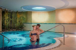 un uomo e una donna in piedi in una piscina di Landhaus St. Georg a Obertauern
