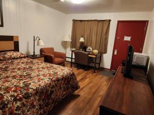 ein Hotelzimmer mit einem Bett und einem Schreibtisch in der Unterkunft Cortland Motel in Cortland