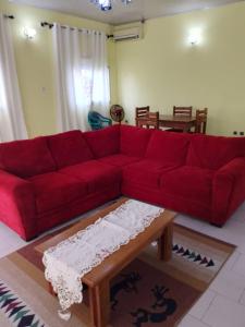 a red couch in a living room with a coffee table at Residence Mindja in Kribi