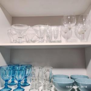 a bunch of wine glasses and bowls on a shelf at Espectacular salto centro in Salto