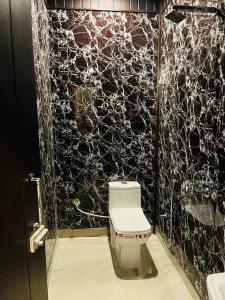 bagno con servizi igienici e parete in bianco e nero di The Bluewind Resort a Dehradun