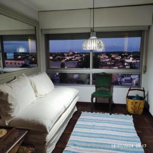 uma sala de estar com um sofá branco e uma grande janela em Espectacular salto centro em Salto