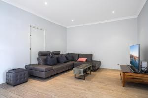 a living room with a couch and a table at DundasParramattatwo-level 3Br HouseWiFi&Parking in Sydney