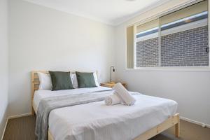 two beds in a room with a window at DundasParramattatwo-level 3Br HouseWiFi&Parking in Sydney