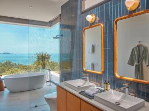 a bathroom with a tub and a sink and mirror at Casa Alma by Elite Havens in Nai Harn Beach +12 photos