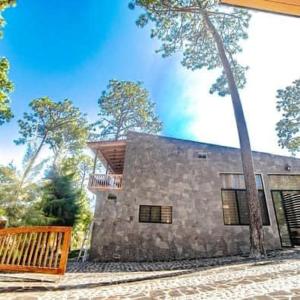 une maison en pierre avec une clôture en bois devant elle dans l'établissement La ocotera hotel de montaña, à San Marcos